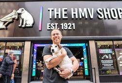 HMV owner Doug Putman poses with a dog outside HMV's Oxford Street store