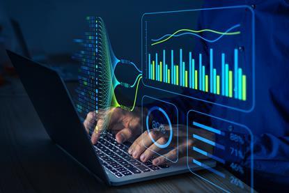 Person typing at a computer with graphics showing charts and stats